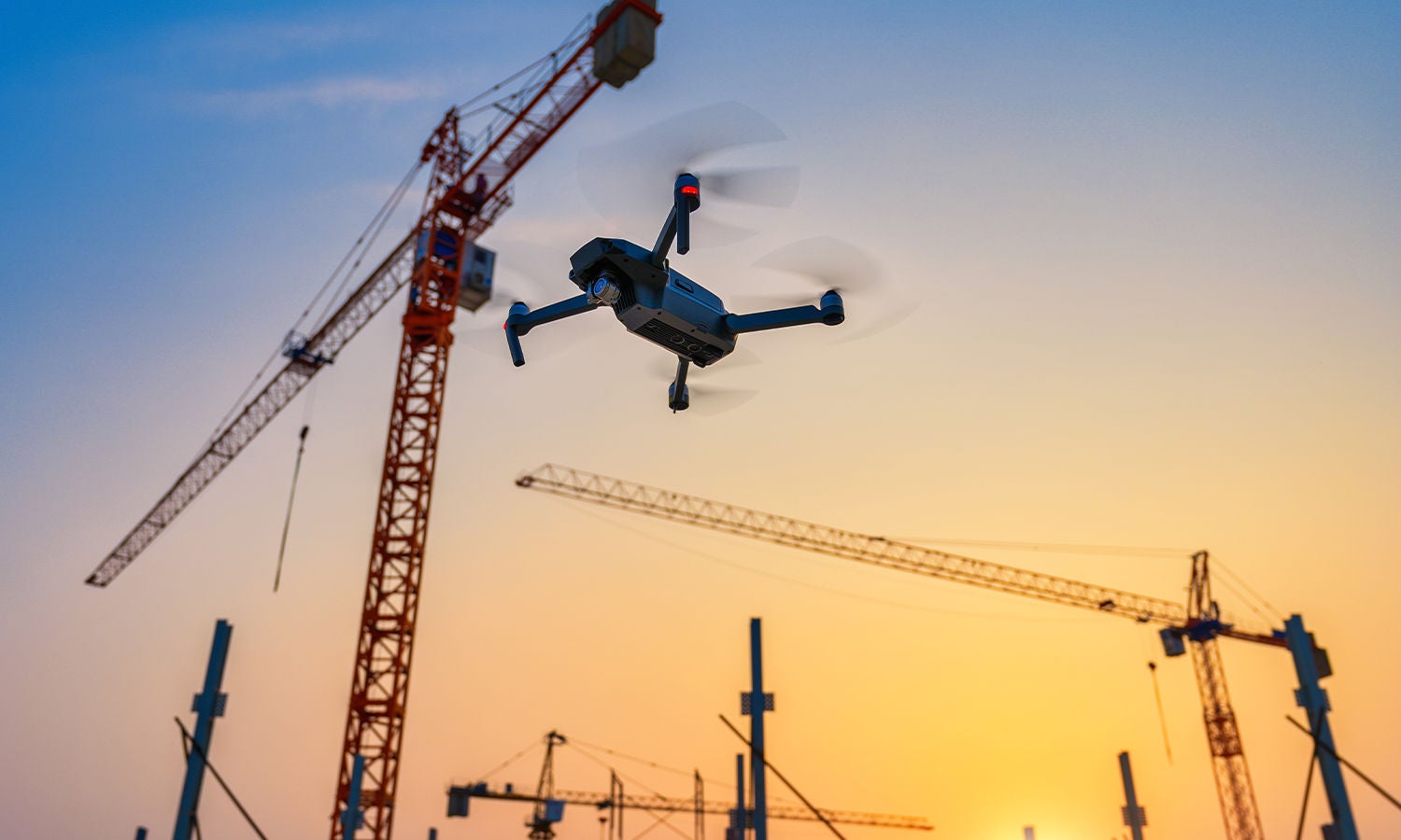 Drone flying over construction cranes